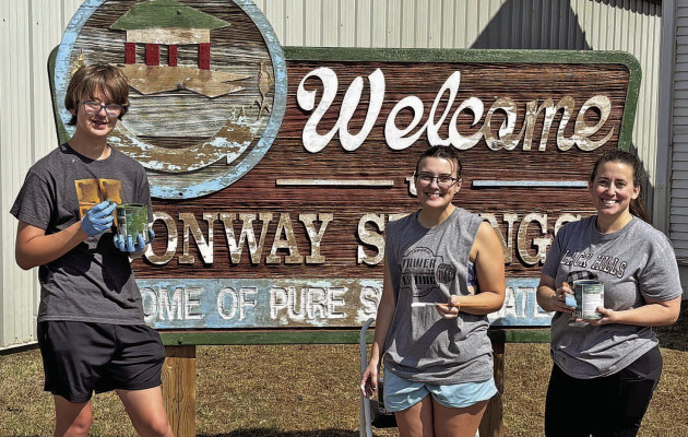 Troy Herndon, a junior at Conway Springs High School, and Aliette Potts, a senior at CSHS, as well as their teacher, Jennifer Potts, volunteered to paint the historic sign outside the Conway Springs Historical Museum. Contributed photo