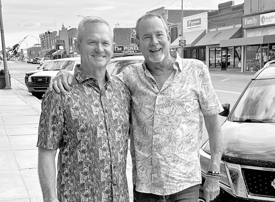 Publisher Paul Rhodes stops on Main Street of Smith Center, Kan., for a photo with Mitch Holthus, the voice of the Kansas City Chiefs. Both graduated from Smith Center High School in 1997.