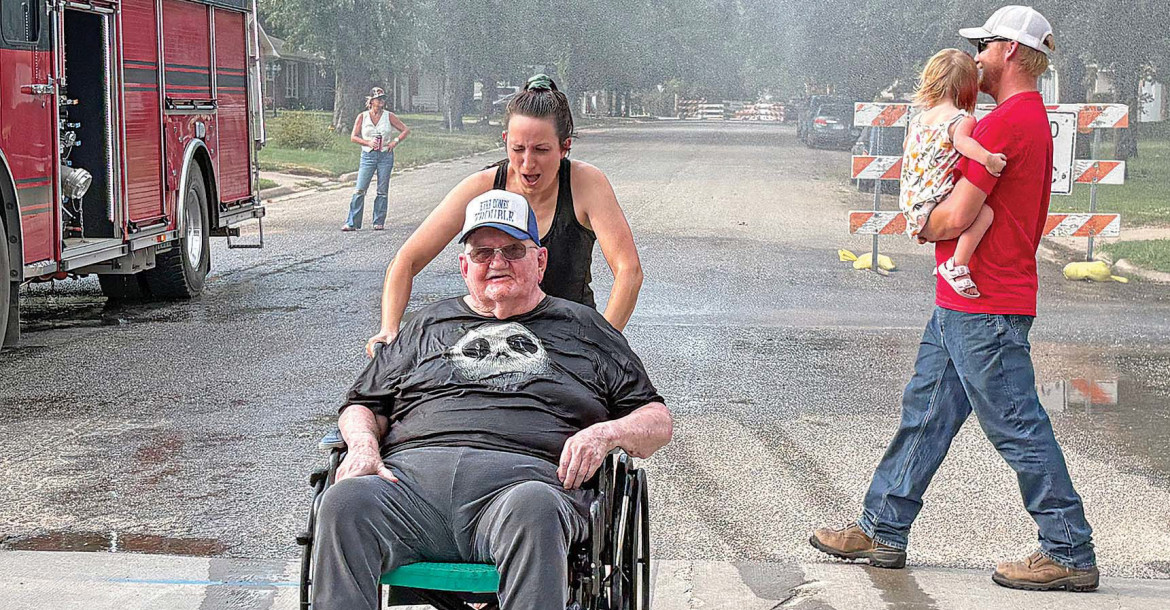 ABOVE: Springview Manor resident Bob Thomas enjoys the spray from the Conway Springs Fire Department during last week’s National Night Out. Springview Manor employee April Curry is assisting him. BELOW: Siblings Madison and Alan Borzek enjoy shaved ice during Goddard’s National Night Out event, which took place last Friday. Contributed photo and Dale Stelz/TSnews